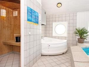 埃贝尔托夫特6 person holiday home in Ebeltoft的白色的浴室设有浴缸和水槽。