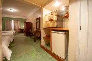 亚松森Granados Park Hotel的酒店客房配有一张床、一张书桌和一间厨房。