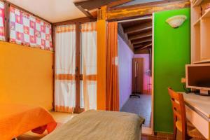 加利波利ATTICO SUL MARE的一间卧室设有绿色和黄色的墙壁,配有电视
