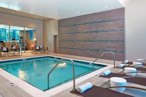 亚特兰大亚特兰大巴克海特菲普斯广场万豪AC酒店的游泳池位于酒店带桌椅的客房内