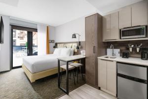 纽约TownePlace Suites by Marriott New York Manhattan/Chelsea的酒店客房带一张床和一个厨房