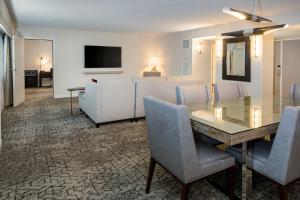 罗缪勒斯底特律大都会喜来登酒店机场店的客厅配有餐桌和沙发