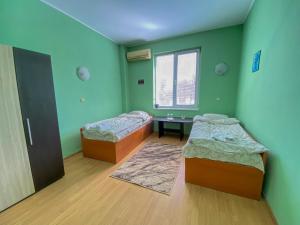 斯维什托夫Пансион - Димитър Хадживасилев的绿墙客房内的两张床