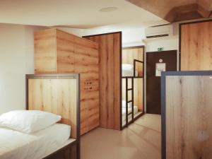 新戈里察GARAGE HOSTEL的一间卧室设有一张床和木墙