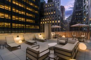 纽约Courtyard New York Downtown Manhattan/Financial District的一座带桌椅的屋顶露台和建筑