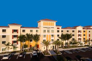 埃斯特罗TownePlace Suites by Marriott Fort Myers Estero的停车场前方的棕榈树建筑