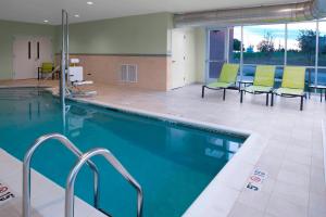 雷内克萨SpringHill Suites by Marriott Kansas City Lenexa/City Center的一座带绿色椅子的游泳池
