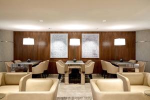 达拉斯AC Hotel by Marriott Dallas Downtown的餐厅设有桌椅和木墙