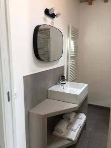 乌尔比诺B&B Il Passo的浴室配有盥洗盆、镜子和毛巾