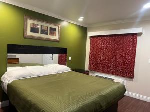奥克兰哈里斯汽车旅馆的一间卧室设有一张床和一个红色的窗户