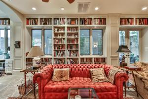 休斯顿Elegant French Patio Home with Private Pool的一间带红色沙发和书架的客厅