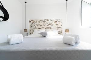 LiaropáSanta Marina Syros的白色卧室配有一张带白色床单的大床