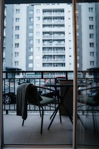 克卢日-纳波卡Smiling Apartment的阳台配有桌椅,设有建筑