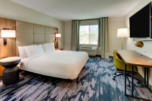 道尔顿Fairfield by Marriott Inn & Suites Dalton的酒店客房设有一张大床和一张书桌。