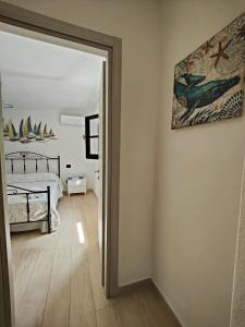 奇亚Villa Su Giudeu的卧室配有一张床,墙上挂有绘画作品