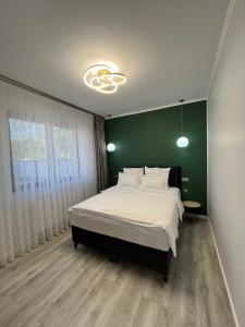 锡比乌Glam Studios的一间卧室设有一张大床和绿色的墙壁