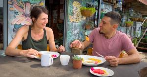 蒙泰韦尔德哥斯达黎加Casa Tranquilo Hostel的坐在餐桌旁吃食物的男人和女人