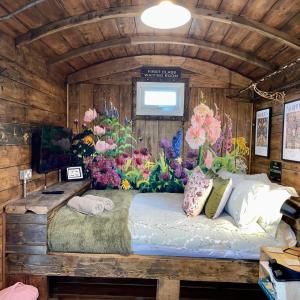Green HammertonSkipbridge Farm Glamping的卧室配有一张墙上鲜花的床