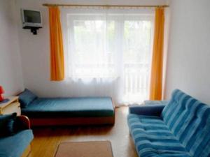 波别罗沃Dom gościnny Moana的客厅设有蓝色的沙发和窗户。