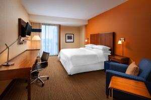 圣何塞圣何塞机场福朋喜来登酒店的酒店客房配有一张床、一张书桌和一张书桌。