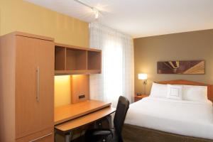 马科尔蒂奥西雅图埃弗里特/马基尔提奥万豪广场套房酒店的一间卧室配有一张床、一张桌子和一张四柱床。