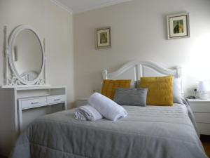庞特维德拉Casa Saladina的卧室配有一张白色的床和大镜子