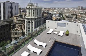 萨拉戈萨阿方索酒店的大楼内带椅子的屋顶和游泳池