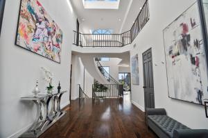 洛杉矶Villa Alana的一条带白色墙壁的走廊和带沙发的楼梯