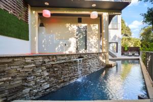 洛杉矶Villa Alana的一座带游泳池和石墙的房子