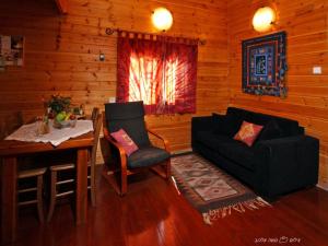纳哈里亚碧柯塔巴马塔木屋的客厅配有沙发、桌子和椅子