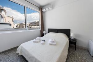 雅典ATHENS COMMERCIAL的一间卧室设有一张床和一个大窗户