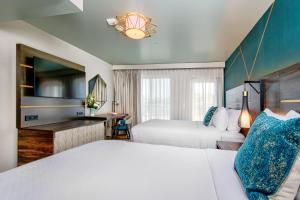 圣克鲁兹Marea Sol Hotel的酒店客房配有两张床和一张书桌