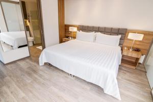 麦德林GHL Hotel Portón Medellín的卧室配有一张白色大床和镜子