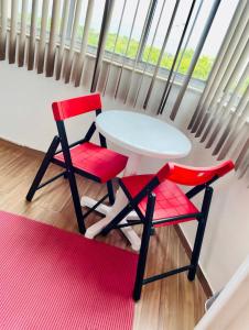 里约热内卢Studio perto de tudo vista Mar Flamengo的窗前的一张白色桌子和两张红色椅子