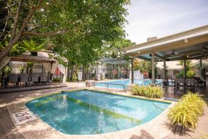 达沃市Casa Julieta Boutique Hotel的一座带椅子和树木的酒店游泳池