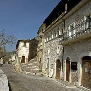 NavelliLa Loggia Di Federico的街道旁的一座古老的石头建筑,设有楼梯