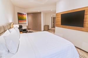 麦德林GHL Hotel Portón Medellín的卧室配有白色床和平面电视