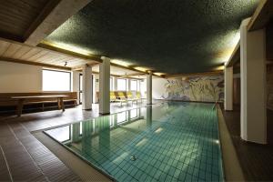 塞纳莱斯艾姆费尔斯酒店的一座带瓷砖地板的建筑中的游泳池