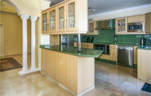 卡拉德米哈斯Awesome Home In Riviera Del Sol With House Sea View的厨房配有木制橱柜和绿色台面