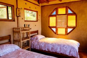 奥尔穆埃Swiss Eco Lodge La Linda Loma - Olmué的一间卧室设有两张床和窗户。
