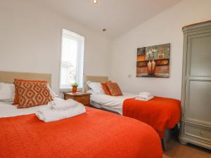 利斯卡德8 Horizon View的一间卧室配有两张带橙色床单的床