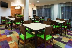 奥德萨敖德萨维尔费尔菲尔德万豪套房酒店的用餐室配有桌子和绿色椅子