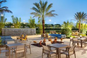 奥兰多奥兰多千禧购物中心万豪春季山丘套房酒店的一个带桌椅的庭院,棕榈树