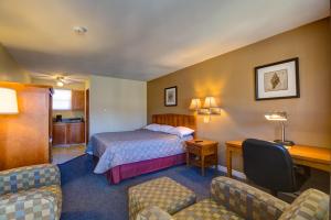 阿尔马高山汽车旅馆的酒店客房,配有一张床、一张桌子和椅子