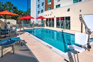 奥本TownePlace Suites by Marriott Auburn University Area的一个带椅子和遮阳伞的游泳池