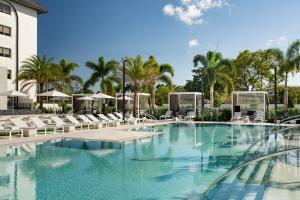 布卡拉顿博卡拉顿万丽酒店 的一座带椅子和棕榈树的度假村游泳池