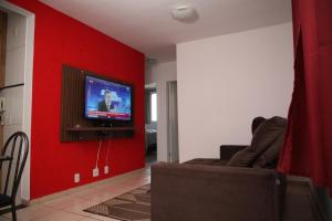 乌贝拉巴Apartamento Aeroporto/ Uniube的客厅设有红色的墙壁,配有电视