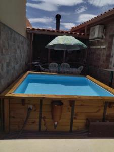 Los YébenesVUT Flor de Romero的后院的游泳池,带遮阳伞