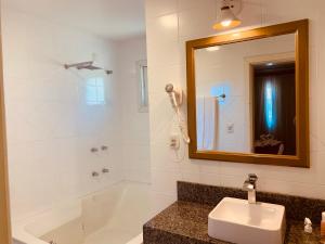 格拉玛多Pousada Quinta do Vale的带浴缸、水槽和镜子的浴室