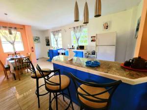ChoiseulComfort Suites - Two Bedroom Apartment的厨房配有蓝色的柜台和一些椅子